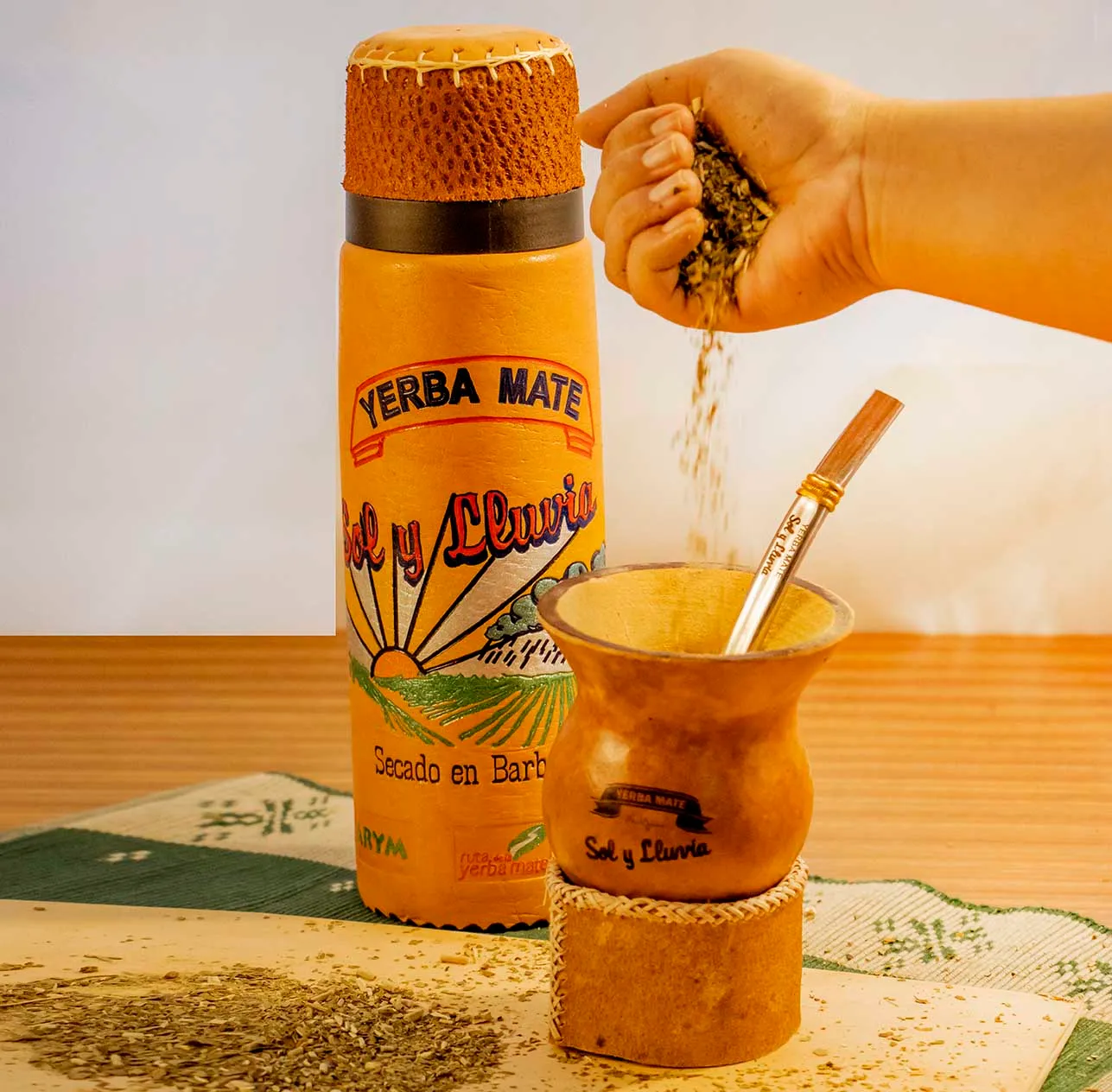 Yerba mate Sol y Lluvia cayendo en un mate junto al termo